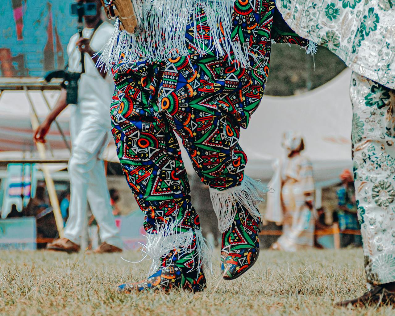 Traditional masquerade dancers in vibrant, colorful costumes at a cultural event in Nigeria.